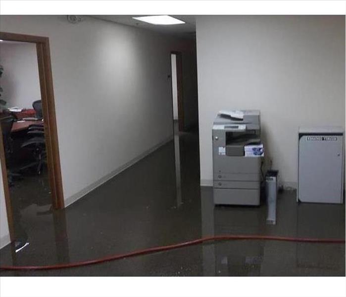 water on floor, red hose, printer visible in office area