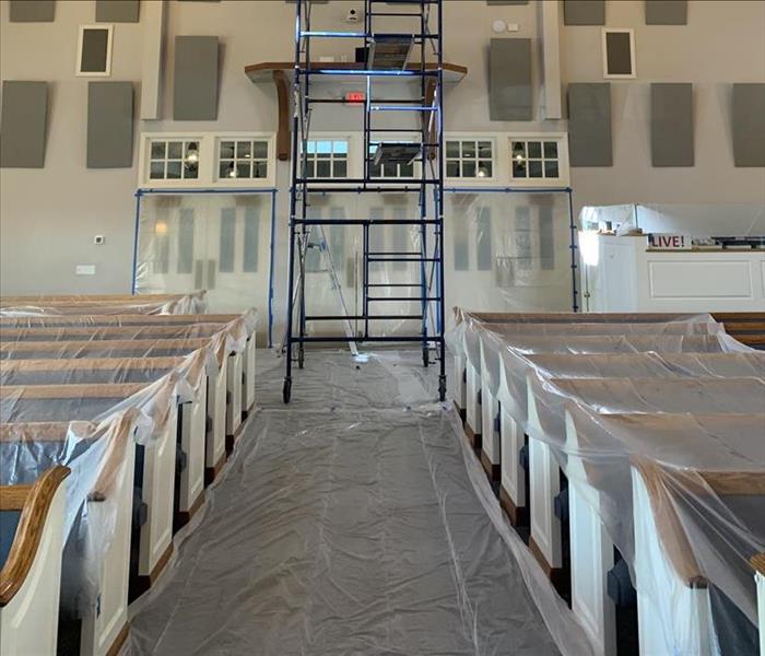plastic sheets on pews, scaffold