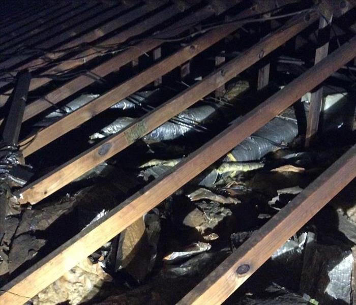 charred insulation and trusses in an attic
