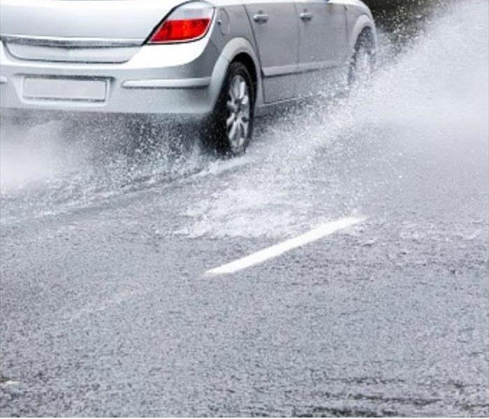 Car Driving Through Water in Roadd